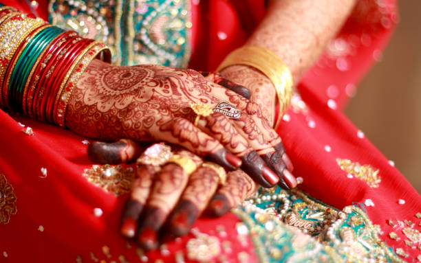 An Indian bride's hands are embellished with intricate mehndi designs.